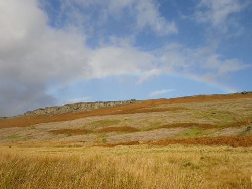 A full rainbow over a wild and windy Stanage.